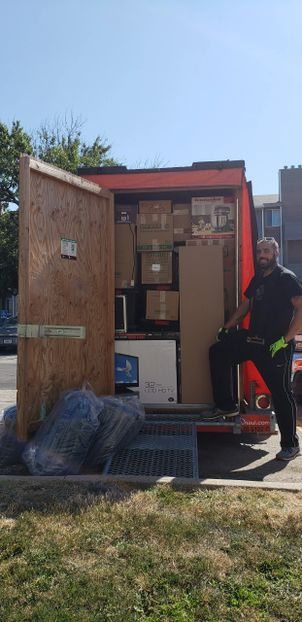 MY Moving Pros mover loading a rental moving truck with a wardrobe box in Omaha