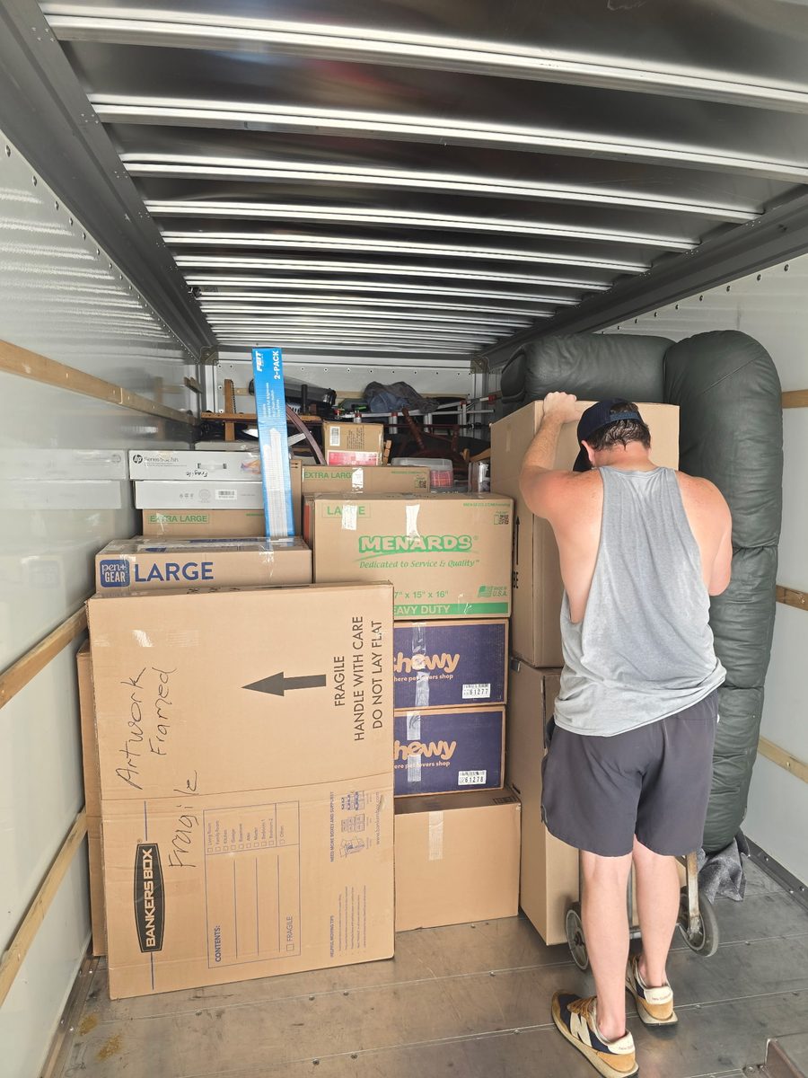 MY Moving Pros crew organizing boxes and furniture inside a rental moving truck
